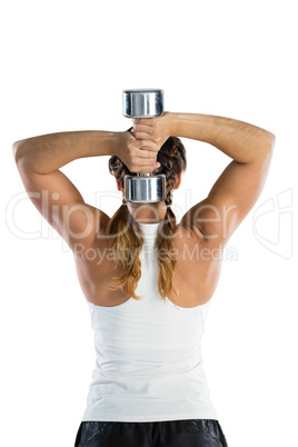 Rear view of female rugby player exercising with dumbbell