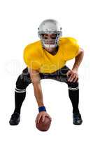 Determined American football player bending with ball