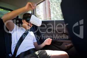 Teenage boy using virtual reality headset in the car