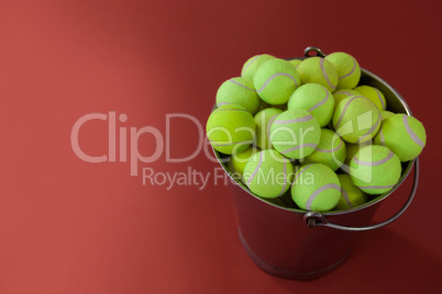 High angle view of fluorescent yellow tennis balls in metallic bucket