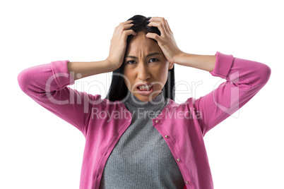 Depressed woman standing against white background