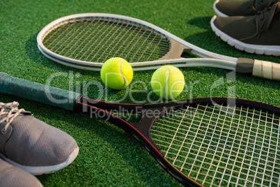 Close up of tennis rackets with balls and sports shoes