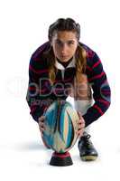 Portrait of female athlete keeping rugby ball on tee