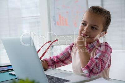 Girl as business executive using laptop while sitting