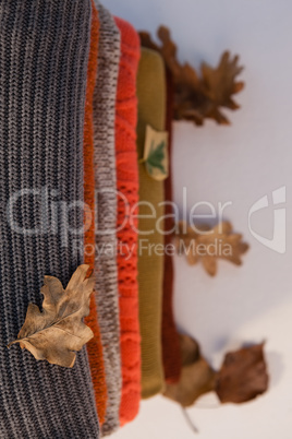 Stack of woolen clothing with autumn leaves