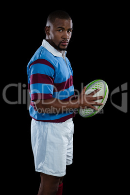 SIde view of male player holding rugby ball