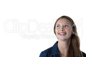 Thoughtful teenage girl smiling against white background