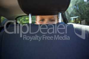 Happy teenage boy sitting in the back seat of car