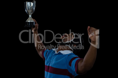 Happy rugby player holding trophy