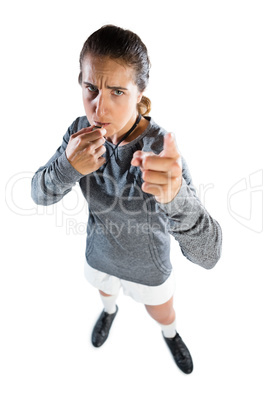 Full length portrait of female coach gesturing while whistling
