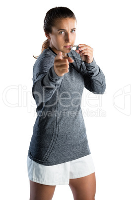 Portrait of female coach gesturing while blowing whistle