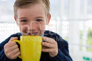 Boy as business executive holding coffee mug