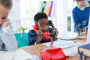 Boy as business executive talking on phone
