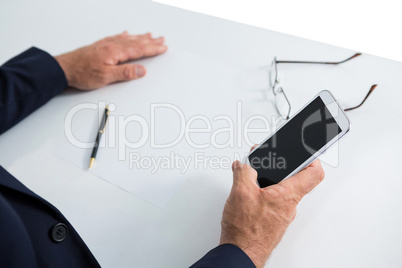 Businessman sitting at table and using mobile phone