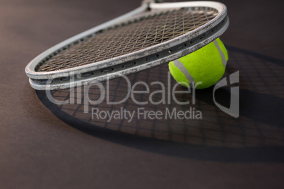 Close up of tennis racket on ball with shadow