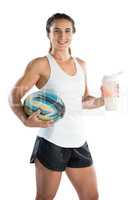 Portrait of happy female rugby player with ball and drinking bottle