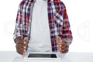 Boy trying to hold the digital tablet against white background