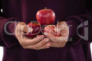 Mid-section of man holding apples