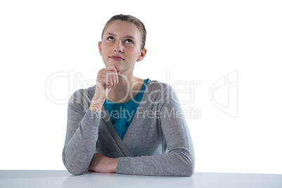 Teenage girl sitting against white background