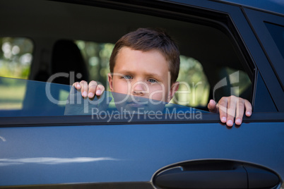 Teenage boy looking from open car window