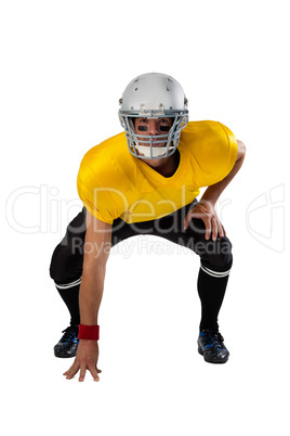 Portrait of American football player wearing helmet bending