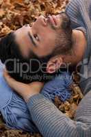 Overhead of man lying on autumn leaves