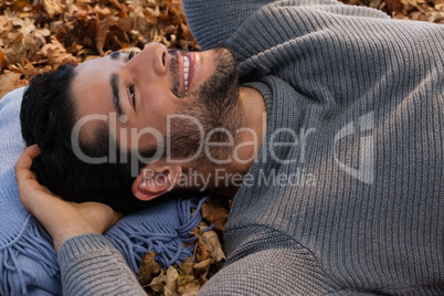 Overhead of man lying on autumn leaves