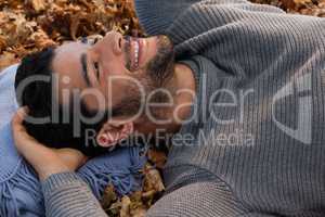 Overhead of man lying on autumn leaves