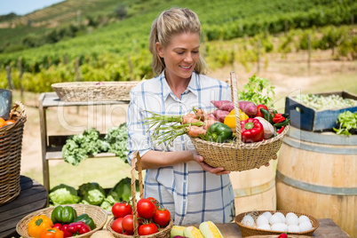 Happy woman holding fresh vegetables in basket