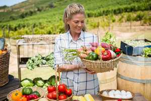 Happy woman holding fresh vegetables in basket