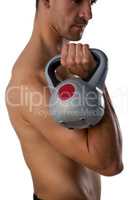 Side view of shirtless sports man exercising with kettle bell
