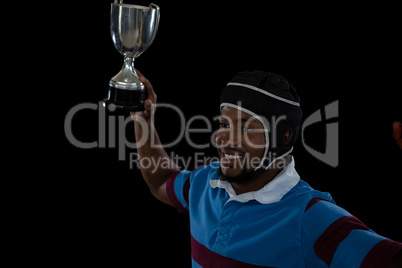 High angle view of happy rugby player holding trophy