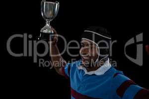 High angle view of happy rugby player holding trophy