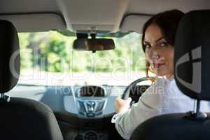 Woman smiling while driving a car