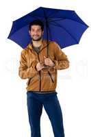 Smiling man standing under umbrella against white background