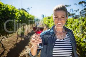 Portrait of female vintner holding glass of wine