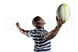Sportsman with arms outstretched holding rugby ball