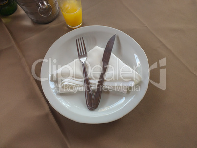 Table with plate and cutlery on napkin