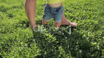 Father and baby boy feet walking barefoot on grass