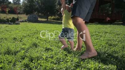 Adorable toddler boy learning to walk outdoors