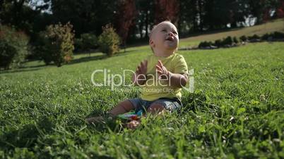 Adorable toddler baby boy clapping hands outdoors