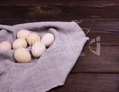 Raw chicken eggs on a gray napkin