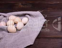 Raw chicken eggs on a gray napkin