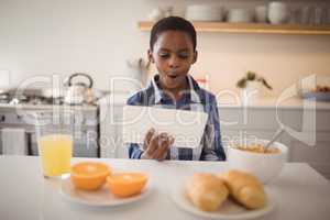 Boy using digital tablet in kitchen