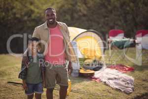 Father and son standing with arm around in park