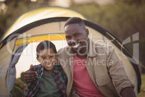 Father and son sitting in park