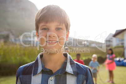 Portrait of smiling boy with friends playing in background