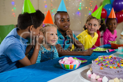 Boy whispering to girl while sitting with friends