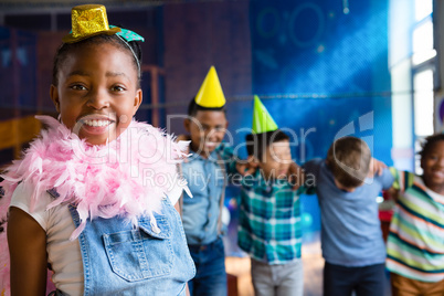 Portrait of girl wearing feather boa with friends in backgroundd