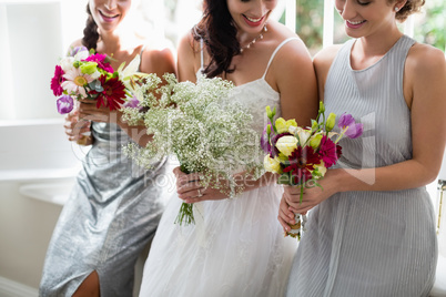 Bride and bridesmaids standing with bouquet